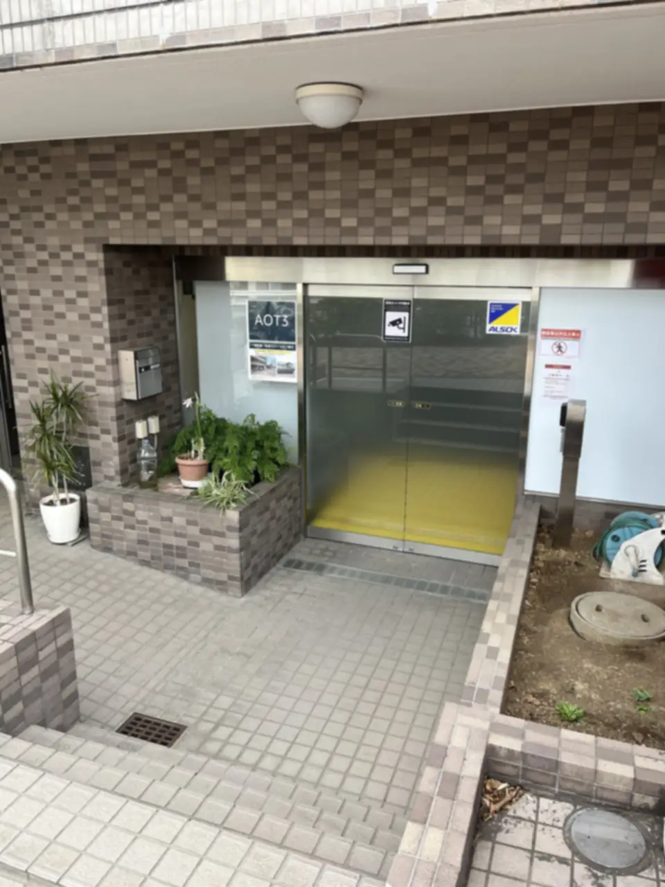 Amazon Now北千束ステーションのAOT3表示が貼られたガラスの入口扉